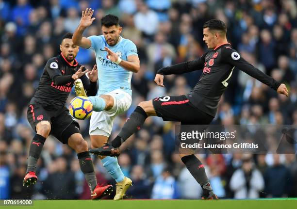 Sergio Aguero of Manchester City battles for the ball with Francis Coquelin and Granit Xhaka of Arsenal during the Premier League match between...