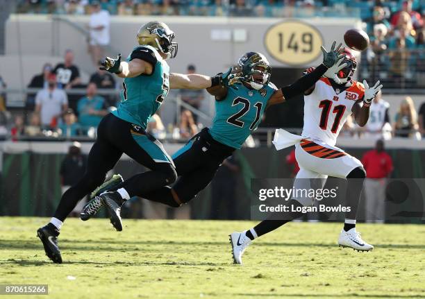 Brandon LaFell of the Cincinnati Bengals reaches for the football in front of Paul Posluszny and A.J. Bouye of the Jacksonville Jaguars in the second...