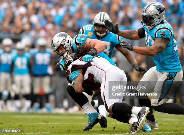 Luke Kuechly of the Carolina Panthers tackles Derrick Coleman of the Atlanta Falcons in the third quarter during their game at Bank of America...