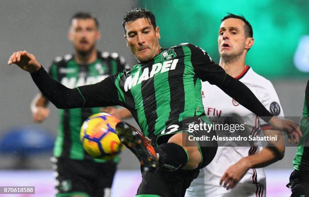 Federico Peluso of US Sassuolo competes for the ball whit Nikola Kalinic of AC Milan during the Serie A match between US Sassuolo and AC Milan at...