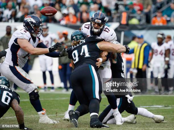 Quarterback Brock Osweiler of the Denver Broncos fumbles the ball as he is sacked by defensive tackle Beau Allen of the Philadelphia Eagles during...