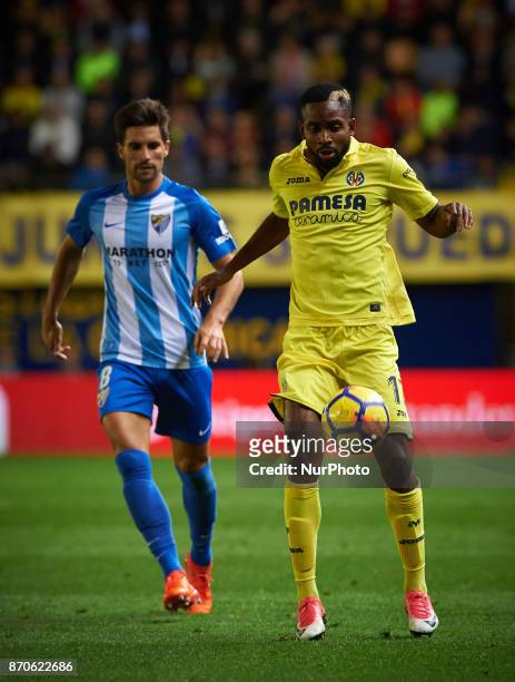 Cedric Bakambu of Villarreal CF and Adrian Gonzalez of Malaga CF in action during the La Liga match between Villarreal CF and Malaga CF at Estadio de...