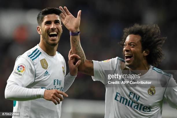 Real Madrid's Spanish midfielder Marco Asensio celebrates with Real Madrid's Brazilian defender Marcelo after scoring a goal during the Spanish...