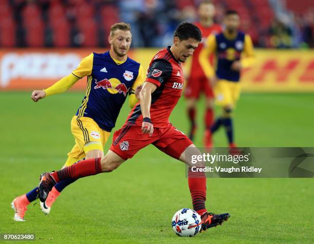 Marky Delgado of Toronto FC dribbles the ball as Daniel Royer of New York Red Bulls defends during the first half of the MLS Eastern Conference...