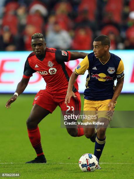 Tyler Adams of New York Red Bulls dribbles the ball as Chris Mavinga of Toronto FC defends during the first half of the MLS Eastern Conference...
