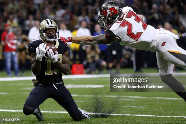 Ted Ginn of the New Orleans Saints catches the ball for a touchdown as Chris Conte of the Tampa Bay Buccaneers defends during the second half of a...