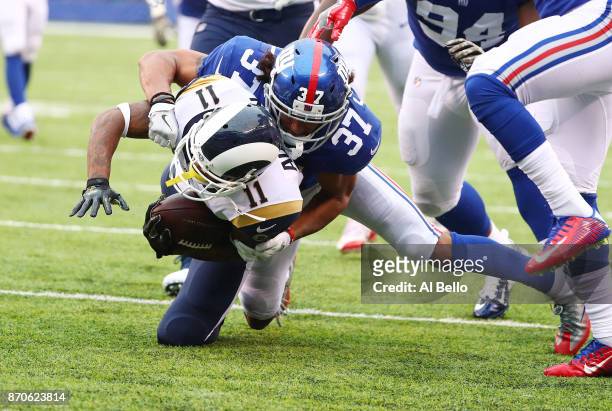 Tavon Austin of the Los Angeles Rams completes a run as Ross Cockrell of the New York Giants makes the tackle during their game at MetLife Stadium on...