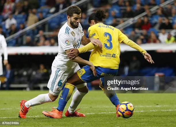 Nacho Fernandez of Real Madrid competes for the ball with Mauricio Lemos of Las Palmas during the La Liga match between Real Madrid and Las Palmas at...