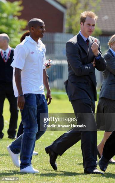 Prince William, President of The Football Association and footballer Ashley Young meet a member player on crutches as they visit Kingshurst Sporting...