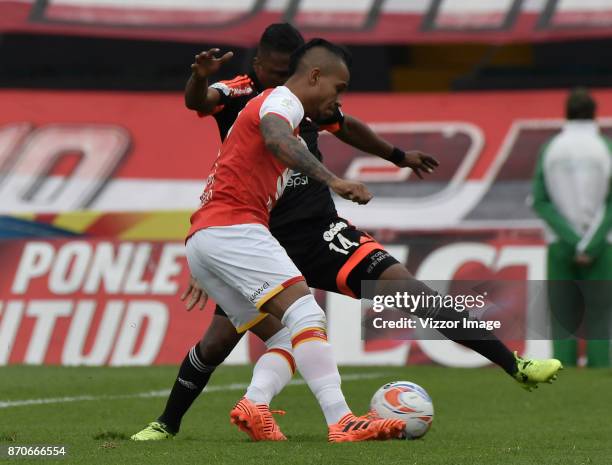 Wilson Morelo of Santa Fe struggles for the ball with Ivan Velez of America during a match between Independiente Santa Fe and America de Cali as part...