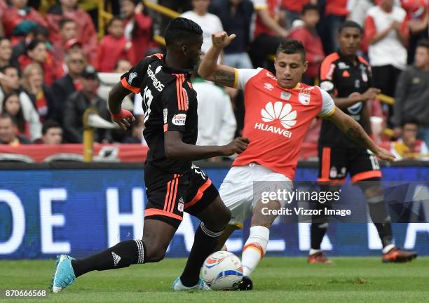 Juan Daniel Roa of Santa Fe struggles for the ball with Olmes Garcia of America during a match between Independiente Santa Fe and America de Cali as...