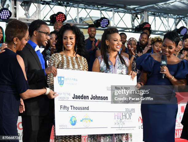 Jaeden Johnson receives a check from Simone Missick, MC Lyte, and President of Hip Hop Sisters Foundation Lynn Richardson during the 2017 Soul Train...