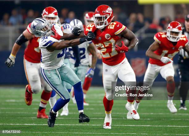 Kareem Hunt of the Kansas City Chiefs holds off Byron Jones of the Dallas Cowboys on a carry in the second half of a football game at AT&T Stadium on...