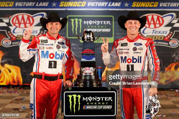 Kevin Harvick , driver of the Mobil 1 Ford, and his crew chief, Rodney Childers, pose with the trophy in Victory Lane after winning the Monster...