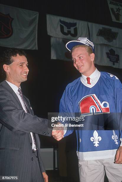 Swedish ice hockey player Mats Sundin wears a Quebec Nordiques jersey and shakes hands with an unidentified man following his first round, first...