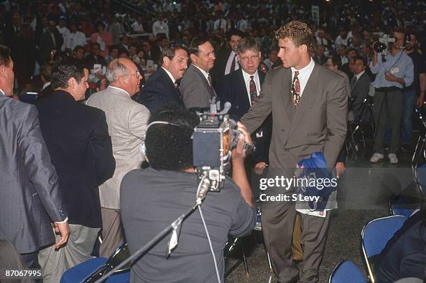 Canadian ice hockey player Eric Lindros shakes hands with a line of unidentified men following his first round, first place selection by the Quebec...