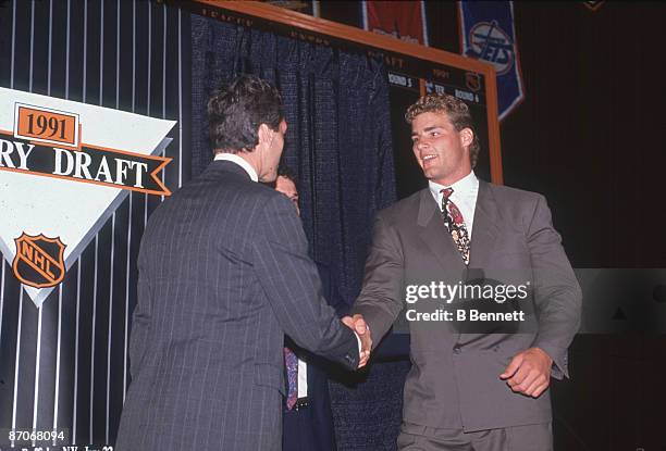 Canadian ice hockey player Eric Lindros shakes hands with an unidentified man following his first round, first place selection by the Quebec...
