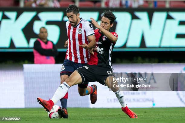 Rodolfo Pizarro of Chivas fights for the ball with Javier Salas of Atlas during the 16th round match between Chivas and Atlas as part of the Torneo...