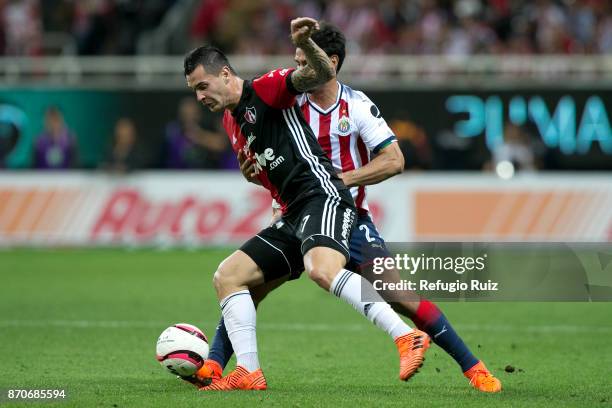 Oswaldo Alanis of Chivas fights for the ball with Milton Caraglio ofAtlas during the 16th round match between Chivas and Atlas as part of the Torneo...