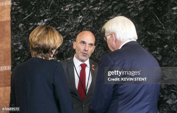 German President Frank-Walter Steinmeier and his wife Elke Budenbender speak with German artist Stephan Schenk at the unveiling of a tapestry at the...