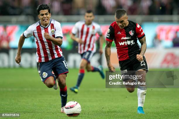 Jesus Sanchez of Chivas fights for the ball with Christian Tabo of Atlas during the 16th round match between Chivas and Atlas as part of the Torneo...