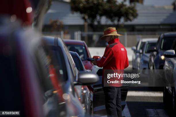 Worker scans a rental vehicle return at an Avis Budget Group Inc. Location at Los Angeles International Airport in Los Angeles, California, U.S., on...