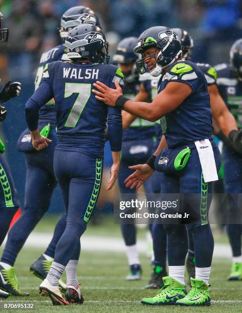Kicker Blair Walsh of the Seattle Seahawks gets a pat on the back from quarterback Russell Wilson after missing one of three field goals against the...