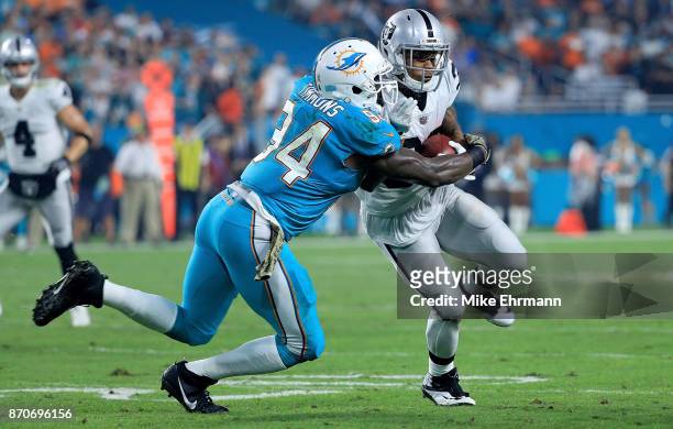 DeAndre Washington of the Oakland Raiders is tackled by Lawrence Timmons of the Miami Dolphins during a game at Hard Rock Stadium on November 5, 2017...