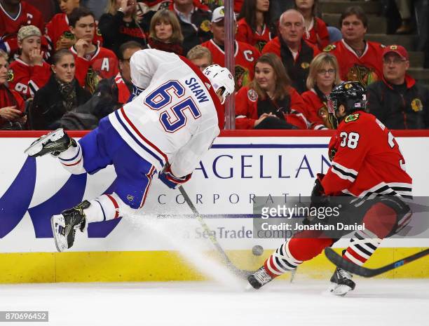 Andrew Shaw of the Montreal Canadiens leaps in the air to take the puck away from Ryan Hartman of the Chicago Blackhawks at the United Center on...