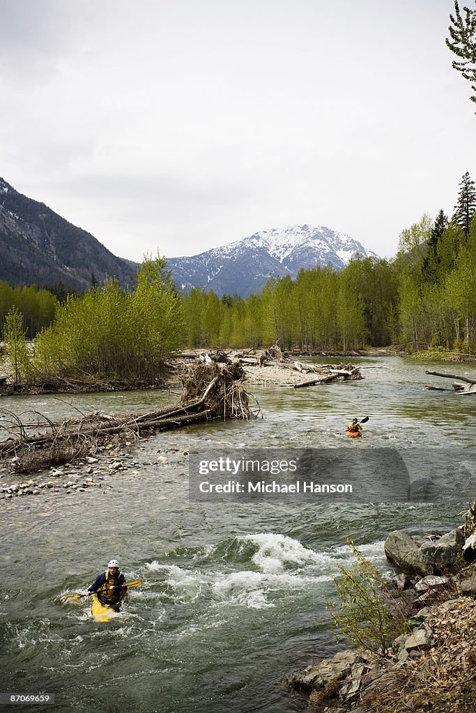 Two kayakers enjoy calm whitewater on a remote river in Washington.