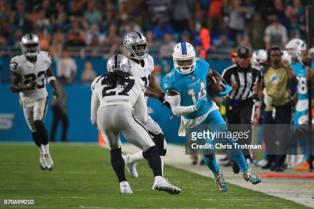 Wide receiver Jarvis Landry of the Miami Dolphins rushes with the ball against free safety Reggie Nelson of the Oakland Raiders at Hard Rock Stadium...