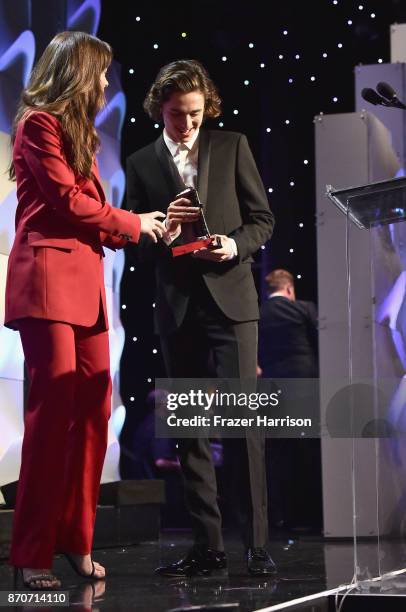 Honoree Timothee Chalamet accepts the Hollywood Breakout Actor Award for 'Call Me By Your Name' from actor Dakota Johnson onstage at the 21st Annual...