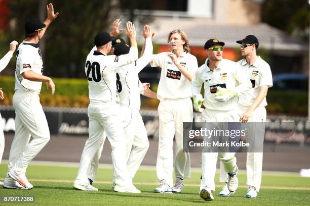 David Moody of the Warriors celebrates with his team after taking the wicket of Nic Maddinson of the Blues during day three of the Sheffield Shield...