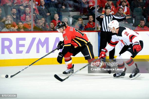 Mikael Backlund of the Calgary Flames skates against John Moore of the New Jersey Devils during an NHL game on November 5, 2017 at the Scotiabank...