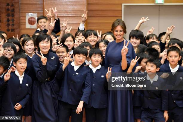 First Lady Melania Trump, third right, and Akie Abe, wife of Japan's Prime Minister Shinzo Abe, third left, pose for photographs with students during...