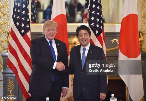 President Donald Trump and Japanese Prime Minister Shinzo Abe shake hands before holding an inter-delegation meeting at Akasaka Palace in Tokyo,...