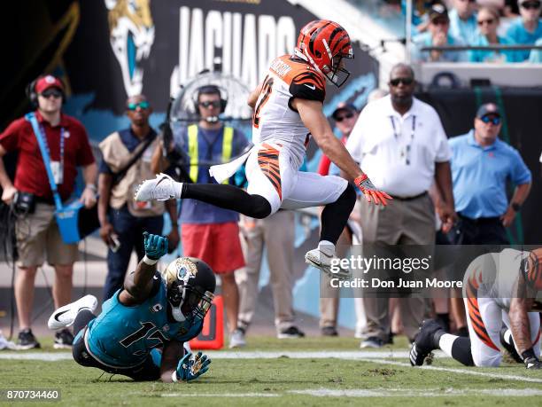 Wide Receiver Alex Erickson of the Cincinnati Bengals leaps over Wide Receiver Arrelious Benn of the Jacksonville Jaguars on a kick-off return during...