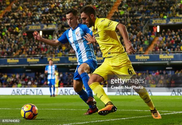 Victor Ruiz of Villarreal CF competes for the ball with Juanpi of Malaga CF during the La Liga match between Villarreal CF and Malaga CF at Estadio...