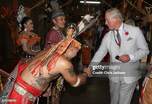 Prince Charles, Prince of Wales shakes hands with locals in traditional dress during a visit to the Sarawak Cultural Village, where visitors are...