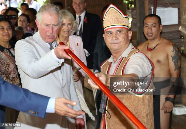 Prince Charles, Prince of Wales studies a blowgun during a visit to the Sarawak Cultural Village, where visitors are encouraged to learn through...