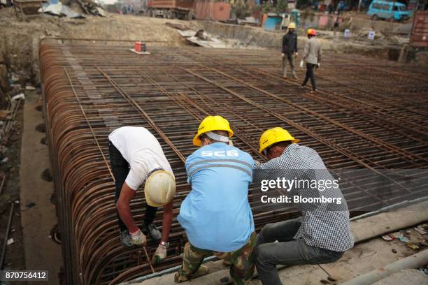 Workers prepare reinforcing steel at a construction site for a road, operated by Shanghai Construction Group Co., in the Kalanki Chowk area of...