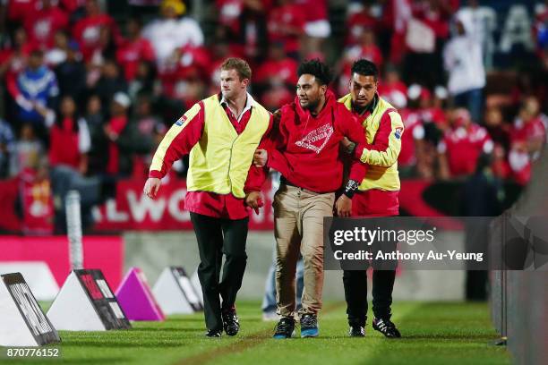 Pitch invader is taken off the field after the 2017 Rugby League World Cup match between Samoa and Tonga at Waikato Stadium on November 4, 2017 in...