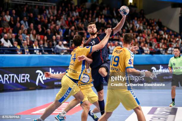 Nedim Remili of Paris Saint Germain is trying to pass the ball against Marko Mamic and Krzysztof Lijewski of PGE Vive Kielce during the Champions...