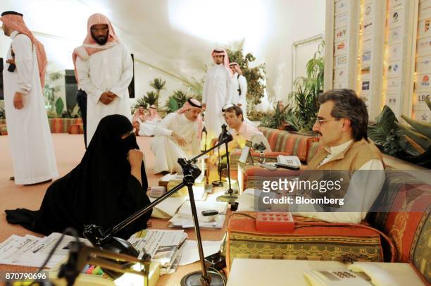 Saudi Prince Alwaleed bin Talal, right, meets citizens who have lined up to ask for the Prince's assistance during an audience at his desert camp...