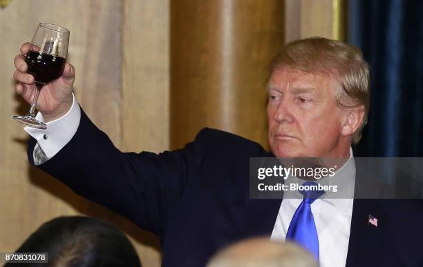 President Donald Trump, raises a wine glass as he toasts after delivering a speech during a state banquet at Akasaka Palace in Tokyo, Japan, on...