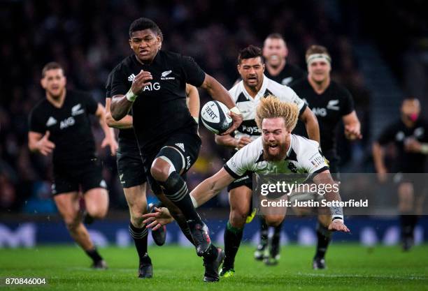 Waisake Naholo of New Zealand evades the tackle of Willie Britz of Barbarians during the Killik Cup between Barbarians and New Zealand at Twickenham...