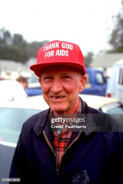 Supporter of the Ku Klux Klan wears a hat thanking god for AIDS, May 4 Stone Mountain, Georgia