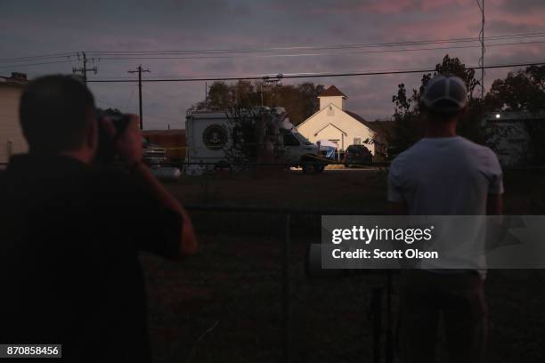 News photographers take pictures as the sun begins to rise on First Baptist Church of Sutherland Springs on November 6, 2017 in Sutherland Springs,...