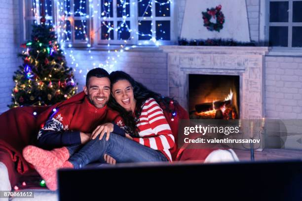 coppia che guarda la tv a casa - christmas couple foto e immagini stock