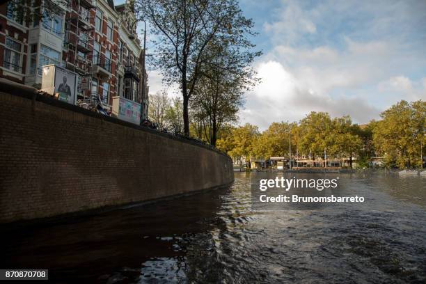 fahrräder im fluss amstel - amsterdã - niederlande - amsterdã stock-fotos und bilder